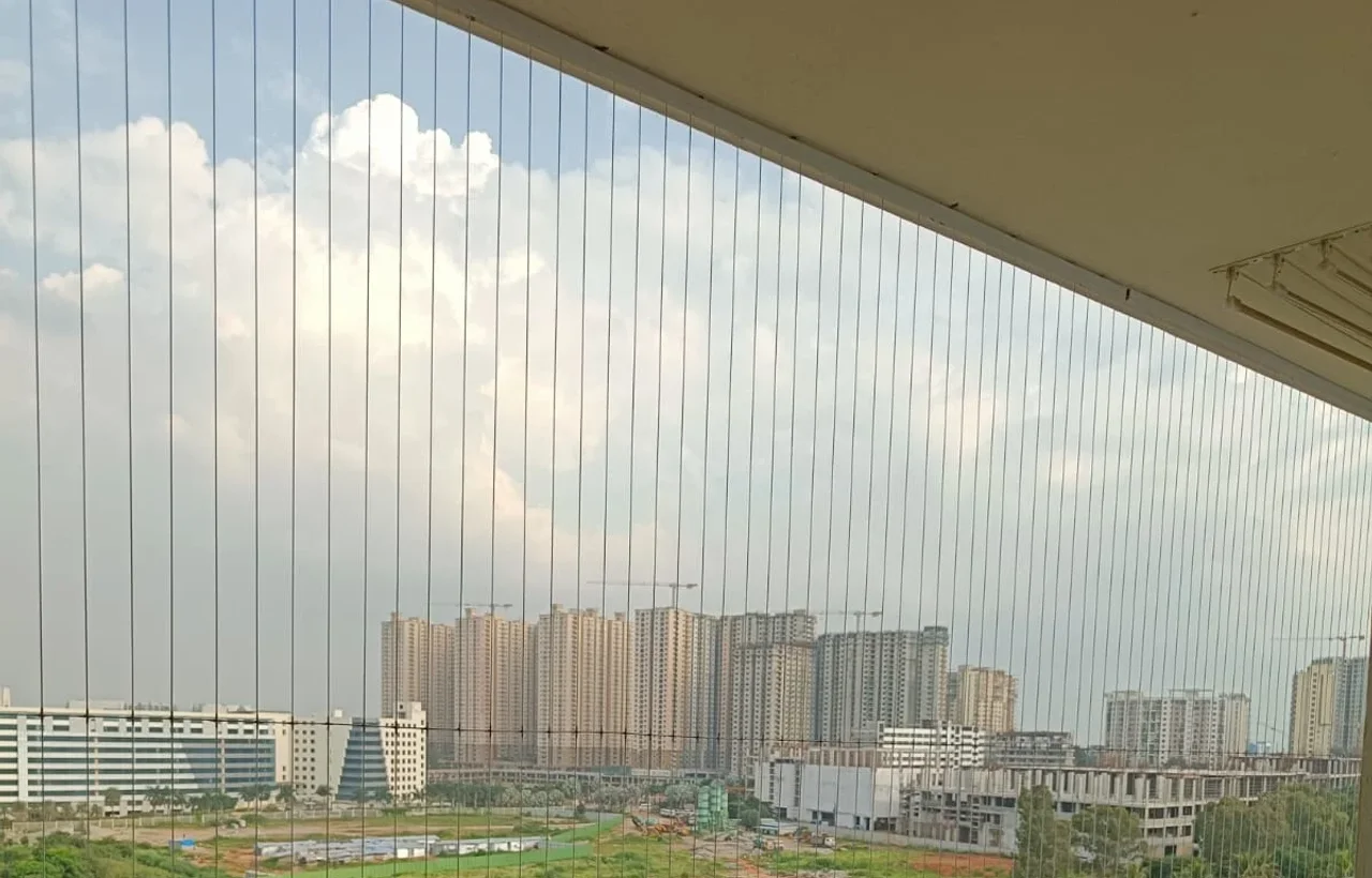 Balcony safety net on an upper floor, city and open ground beyond